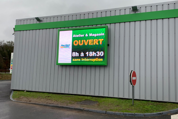 Écran géant sur la façade du magasin Feu Vert